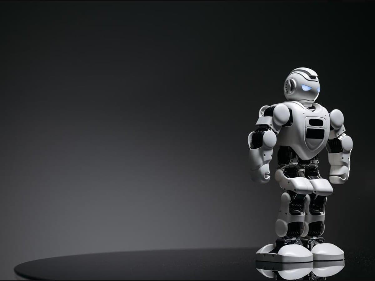 A white bipedal humanoid robot standing in a studio